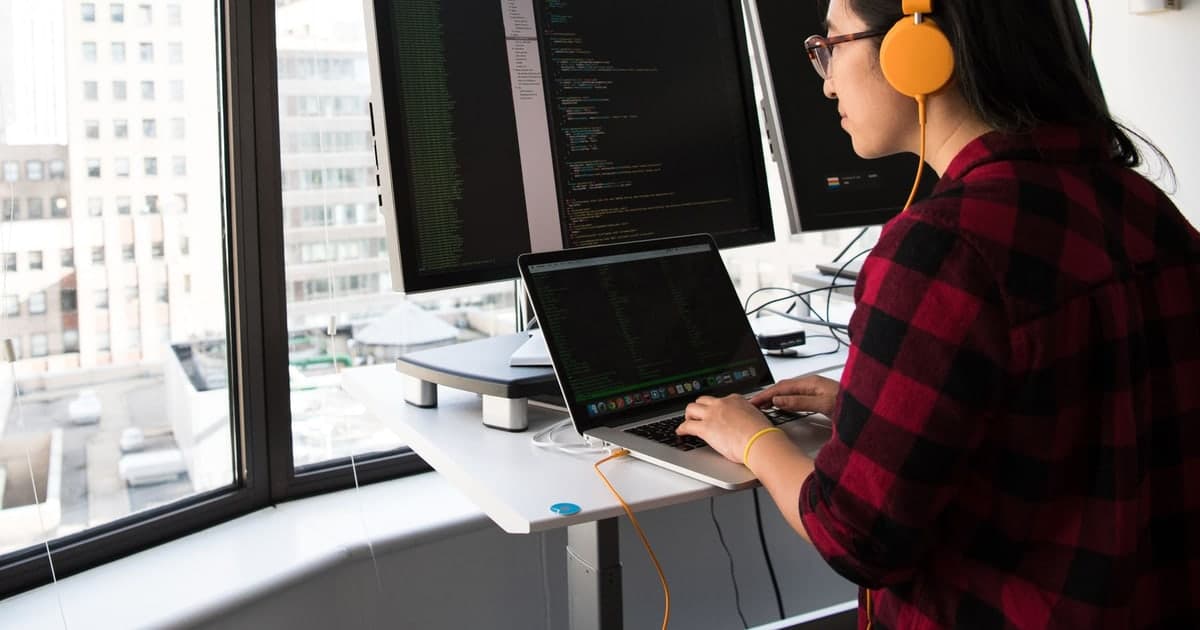 A developer working at a laptop and external monitor